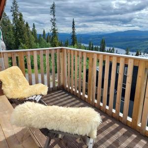 a chair on a deck with a view of the mountains at Villa Bearcorner in Härbyste +4 photos