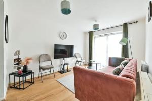 a living room with a couch and a tv at Paprika Nest in Hendon