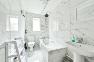 a white bathroom with a sink and a toilet at Paprika Nest in Hendon