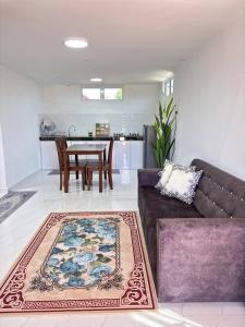 a living room with a couch and a table at Arkan Cottage in Kampong Tok Saboh