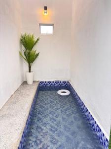 a toilet in a room with blue tiles on the floor at Arkan Cottage in Kampong Tok Saboh