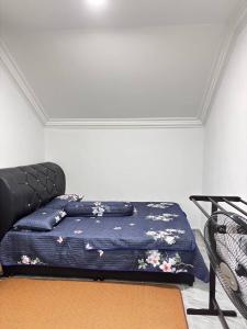 a bedroom with a bed with flowers on it at Arkan Cottage in Kampong Tok Saboh