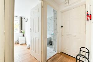 a bathroom with a white door and a mirror at Paprika Nest in Hendon