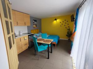 a small room with a kitchen and a table with chairs at Domek dla dwojga w Stegnie in Stegna +4 photos