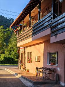 a building with a table and chairs outside of it at Casa Luminita in Brezoi