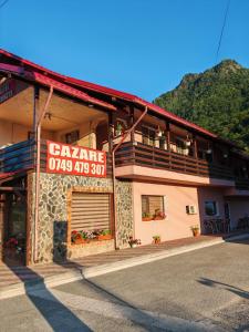 a building with a sign on the side of it at Casa Luminita in Brezoi +14 photos