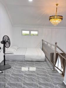 a bedroom with a bed and a fan and a chandelier at Arkan Cottage in Kampong Tok Saboh