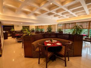 a restaurant with a table and chairs in a room at Hotel Garden Panvel - Near Navi Mumbai Airport in Navi Mumbai