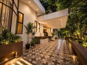 a building with a courtyard with potted plants at Hotel Garden Panvel - Near Navi Mumbai Airport in Navi Mumbai