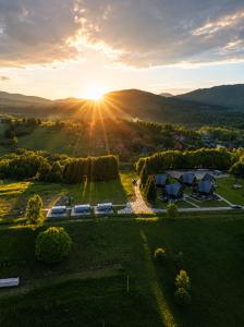 an aerial view of a resort with the sun setting in the mountains at Bieszczadzki Airstream in Wetlina
