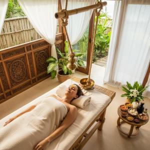 Eine Frau liegt auf einem Bett in einem Zimmer in der Unterkunft Define Spa in Panvel