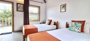 two beds in a room with a window at Bay Rose in Pointe d'Esny