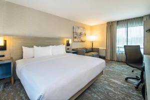 a large white bed in a hotel room at Comfort Inn Saskatoon Centre in Saskatoon