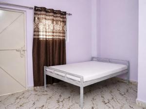 a bed in a room with a curtain at Harshvardhan Lodge in Narsimhapur +5 photos