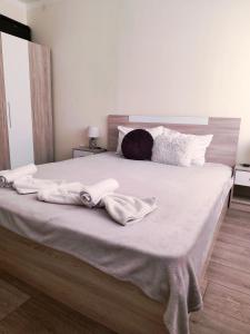 a large bed with white sheets and towels on it at ApartmentDanny in Hisarya