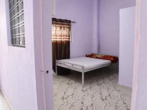 a small room with a bed and a window at Harshvardhan Lodge in Narsimhapur