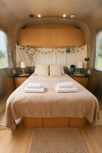 a bedroom with a large bed with two towels on it at Bieszczadzki Airstream in Wetlina