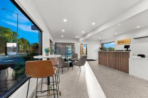a dining room with a table and chairs and a large window at Clarion Pointe Kent - Seattle South in Kent