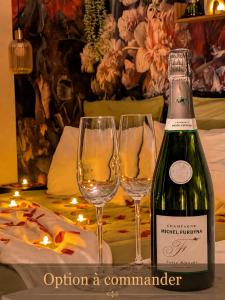 a bottle of wine and two wine glasses on a table at Studio cosy proche étang et commerces in Saint-Aubin-du-Cormier +16 photos