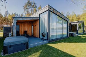 a glass house with a deck and a grill at Lavyso perlai, 1-2 nameliai in lavysas