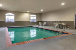 a swimming pool in a building with a table and chairs at Comfort Inn & Suites Cartersville - Emerson Lake Point in Cartersville