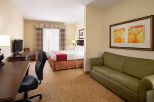 a hotel room with a couch and a bed at Country Inn & Suites by Radisson, Albany, GA in Albany
