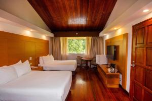 ein Hotelzimmer mit zwei Betten und einem Fernseher in der Unterkunft Hotel Faranda Bambito Chiriquí, a member of Radisson Individuals in Cerro Punta