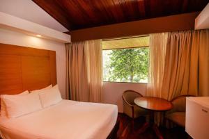 ein Hotelzimmer mit einem Bett und einem Fenster in der Unterkunft Hotel Faranda Bambito Chiriquí, a member of Radisson Individuals in Cerro Punta