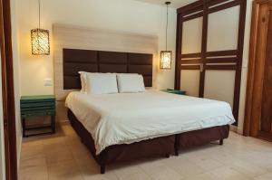 a bedroom with a large bed with white sheets at Hotel Faranda Guayacanes, a member of Radisson Individuals in Chitré