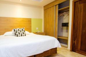 a bedroom with a large white bed and a closet at Hotel Faranda Guayacanes, a member of Radisson Individuals in Chitré +100 photos