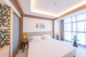 a bedroom with a white bed and a large window at Hotel Faranda Rias Altas, Ascend Hotel Collection in Oleiros