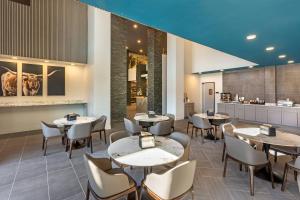 a restaurant with tables and chairs and a kitchen at The Valor, an Ascend Collection Hotel in Parowan