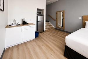 a bedroom with a bed and a kitchen with a sink at Maritime Inn Port Hawkesbury in Port Hawkesbury