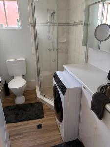 a bathroom with a shower and a washing machine at Surfers 641 in Gold Coast +8 photos