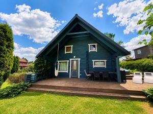 a small blue house with a wooden deck at Hubane palkmaja Otepää südames in Otepää +13 photos