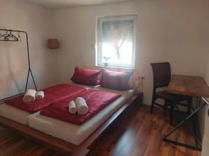 a bed in a room with a window and a table at Ferienhaus Auszeit in Höchstädt an der Donau +10 photos