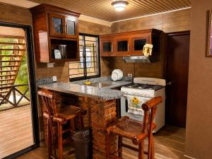 a kitchen with a stove and a counter with stools at Villas alpinas in Concepción de La Vega