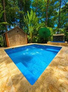 a blue swimming pool with an umbrella in a yard at Villas alpinas in Concepción de La Vega