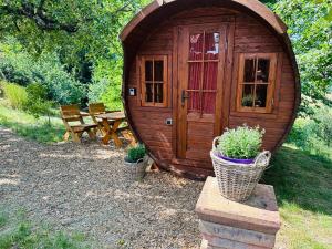 a wooden cabin with two potted plants and a picnic table at Schlaffass im Apfelhain in Hohenraunau