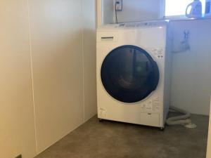 a washing machine in a corner of a room at cocomio in Bungoono