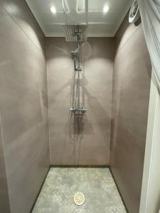 a shower in a bathroom with a wall at Idyllic cottage with lake view with 11 beds in Ludvika
