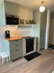 a small kitchen with a stove and a refrigerator at Idyllic cottage with lake view with 11 beds in Ludvika +6 photos