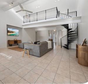 a living room with a couch and a staircase at Smada Stay - 4BR, Waterfront, Perfect Entertainer in Port Lincoln +51 photos