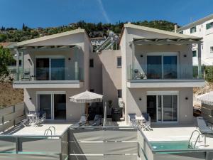 a villa with a swimming pool and a house at Aurea Ionian Villas in Apolpaina