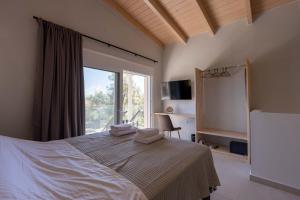 a bedroom with a bed and a large window at Aurea Ionian Villas in Apolpaina +30 photos
