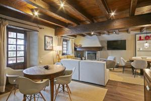 a living room with a table and chairs and a fireplace at Luderna - Casa con terraza Cuylas in Baqueira-Beret
