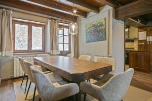 a dining room with a wooden table and chairs at Luderna - Casa con terraza Cuylas in Baqueira-Beret
