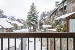 a view from the balcony of a town in the snow at Luderna - Casa con terraza Cuylas in Baqueira-Beret