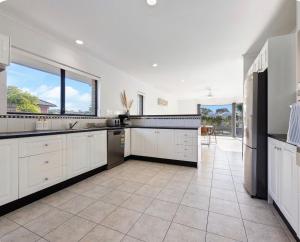 a large kitchen with white cabinets and a large window at Smada Stay - 4BR, Waterfront, Perfect Entertainer in Port Lincoln