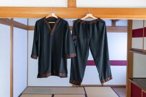 two black graduation robes hanging on a rail at 鈴木旅館 in Joetsu +72 photos